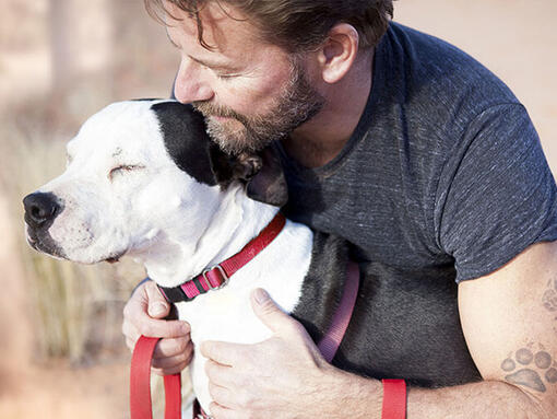 Hombre abrazando a un perro